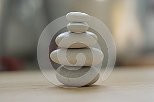 Harmony and balance, cairns, simple poise pebbles on wooden light white gray background, simplicity rock zen sculpture