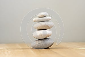 Harmony and balance, cairns, simple poise pebbles on wooden light white gray background, simplicity rock zen sculpture