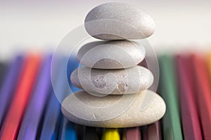 Harmony and balance, cairns, simple poise stones on colorful background, rock zen sculpture, white pebbles, single tower