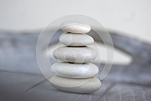 Harmony and balance, cairns, simple poise stones on white background, rock zen sculpture, five white pebbles, single tower