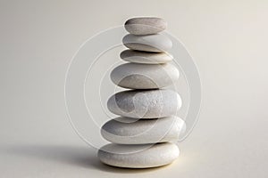 Harmony and balance, cairns, simple poise stones on white background, rock zen sculpture, white pebbles, single tower, simplicit