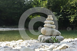 Harmony, balance and simplicity concept. A stone pyramid on the background of river water. Simple poise pebbles, rock zen