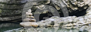 Harmony, balance and simplicity concept. A stone pyramid on the background of river water. Simple poise pebbles, rock zen