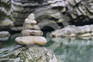 Harmony, balance and simplicity concept. A stone pyramid on the background of river water. Simple poise pebbles, rock zen