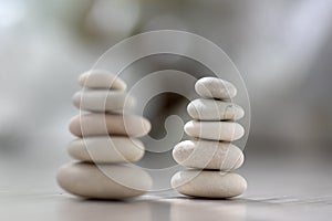 Harmony and balance, two cairns, simple poise pebbles on wooden light white gray background, simplicity rock zen sculpture