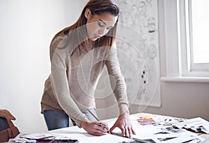 Harnessing her creativity. A young woman working on her portfolio at home.