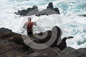 Harpoon spear fisherman at rocky shore