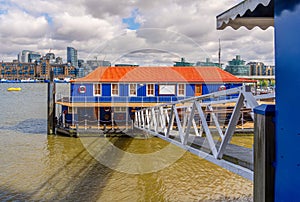 The Harpy houseboat illuminated by morning sunlight on the south bank of the River Thames, Bermondsey, London, England photo