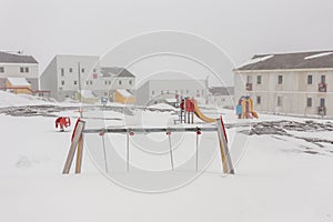 Harsh greenlandic childhood,playground covered in snow and ice photo