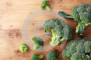 Harvest of fresh green broccoli on wooden table top view