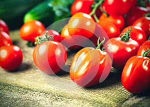 Harvest of fresh ripe tomatoes on wooden table. photo