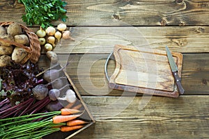 Harvest fresh vegetables from carrot, beetroot, onion, garlic on old wooden board. Top view. Gardening. Copy space.