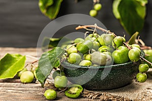 Harvest of ripe Actinidia arguta kiwi in a ceramic bowl