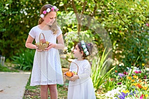 Jewish Holiday Shavuot.Harvest.Two little girls in white dress holds a basket with fresh fruit in a summer garden.