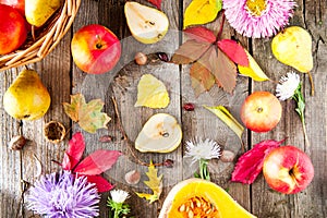Harvest or Thanksgiving background with autumnal fruits, flowers, leaves, pumpkin, nuts and berries on the rustic wooden table. Au