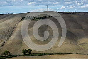 Harvested Fields and meadows landscape in Tuscany, Italy. Wavy country scenery at autumn sunset.