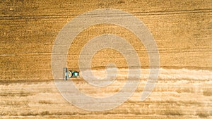 Harvester working in field and mows wheat. Ukraine. Aerial view.