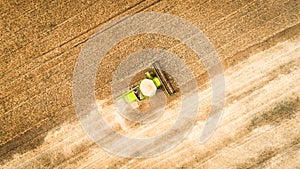 Harvester working in field and mows wheat. Ukraine. Aerial view.