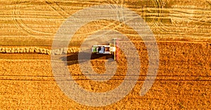 Harvester working in field and mows wheat. Ukraine. Aerial view.