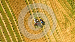 Harvester working in field and mows wheat. Ukraine. Aerial view.