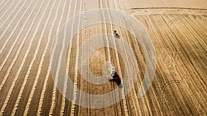 Harvester working in field and mows wheat. Ukraine. Aerial view.