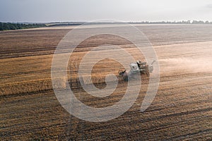 Harvester working in field and mows wheat. Ukraine. Aerial view.