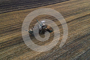 Harvester working in field and mows wheat. Ukraine. Aerial view.