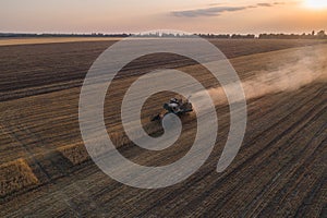 Harvester working in field and mows wheat. Ukraine. Aerial view.