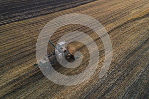 Harvester working in field and mows wheat. Ukraine. Aerial view.