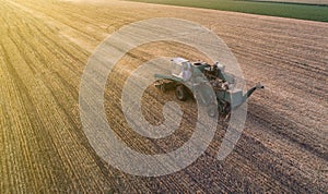 Harvester working in field and mows wheat. Ukraine. Aerial view.