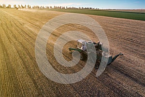 Harvester working in field and mows wheat. Ukraine. Aerial view.