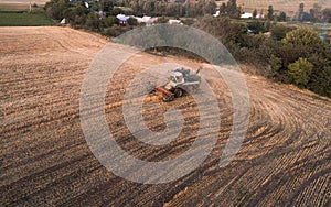 Harvester working in field and mows wheat. Ukraine. Aerial view.