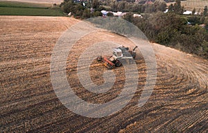 Harvester working in field and mows wheat. Ukraine. Aerial view.