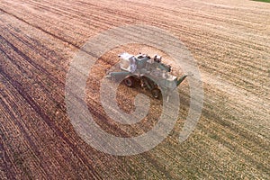 Harvester working in field and mows wheat. Ukraine. Aerial view.