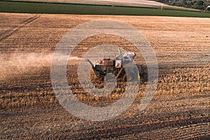 Harvester working in field and mows wheat. Ukraine. Aerial view.