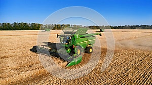 Harvester works in the field. Combine Harvesting Wheat. Field field of cereals during harvesting. Modern equipment works