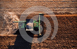 Harvester works in the field. Combine Harvesting Wheat, top view of a wheatfield. Field field of cereals during