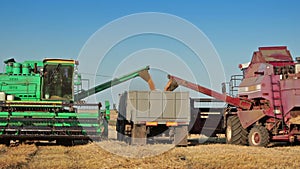 Harvesters unloads grain into truck