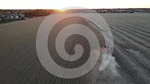 Harvesting corn in autumn. Aerial top view. Aerial drone shot of corn harvest. Harvester machine working in a field at sunset