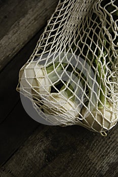 Harvesting fresh white turnip vegetable. organic turnips in cotton net on genuine wood background. selective focus