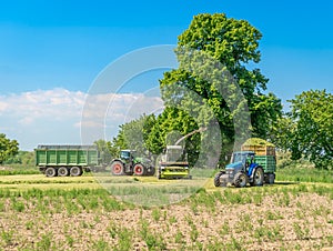 Harvesting hay from the field with the help of a combine harvester and a tractor