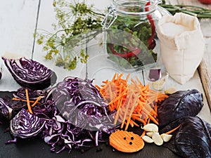 Harvesting vegetables. Sliced cabbage, carrot, garlic on a black board. Preparation for fermentation. Natural, organic food.