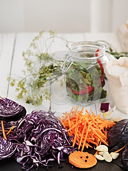 Harvesting vegetables. Sliced cabbage, carrot, garlic on a black board. Preparation for fermentation. Natural, organic food.