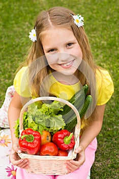 Harvests of vegetables - smiling girl with basket of vegetables photo