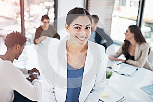 She has all the skills to be a great leader. Portrait of a businesswoman in an office with her colleagues in the