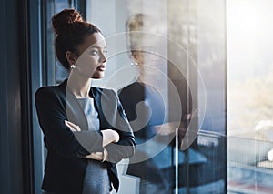 She has the ambitious drive to never give up. a young businesswoman looking out the window in an office.