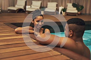 This has been a great bonding experience. a young couple relaxing in a pool at a spa.