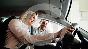 She has bought her dream car. Young woman sitting at the front seat of the car