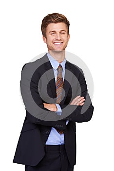 He has a confident demeanor. Portrait of a happy young businessman standing with his arms folded.