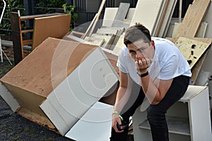 After he has done his  work teenage boy sits  in the bulky refuse